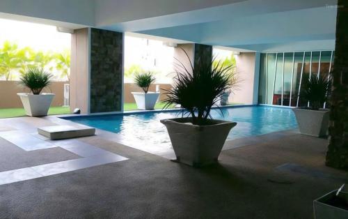 a swimming pool with potted plants in a building at De Viana Apartments Homestay in Kota Bharu