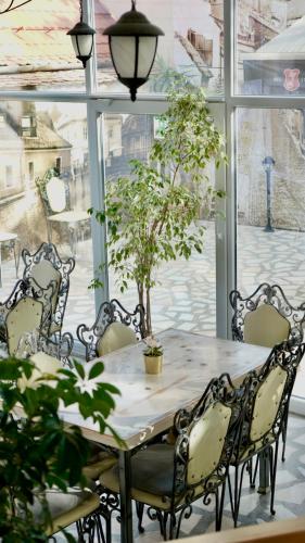 a dining room table with chairs and a potted plant at Pensiunea Cardinal in Sibiu