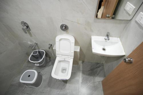 a bathroom with a toilet and a sink at Maruti Grand Hotel in Rajkot