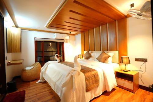 ein Schlafzimmer mit einem großen Bett mit Schwänen darauf in der Unterkunft IndraprasthamLakeCruise in Alappuzha
