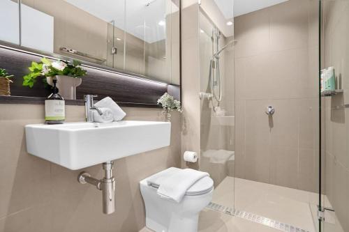 een badkamer met een wastafel, een toilet en een douche bij NEW Waterfront Living With Sublime Views 2B1B in Melbourne
