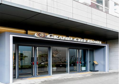 a grand city hotel with a sign on the front of it at Grand City Hotel Changwon in Changwon