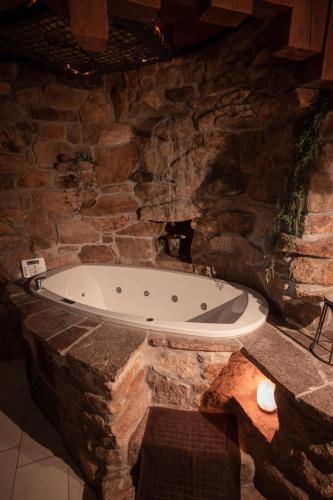 a stone bathroom with a tub in a stone wall at luxeriöses Chalet mit Erdverbundenheit in Viechtach