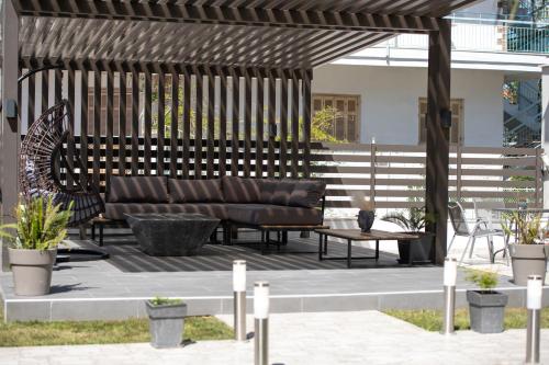 a wooden pergola with a couch on a patio at StayInn Luxury Apartments in Nea Kalikratia