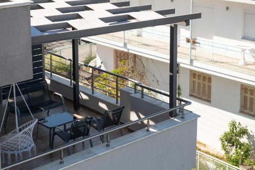 a balcony with a table and chairs on a building at StayInn Luxury Apartments in Nea Kalikratia