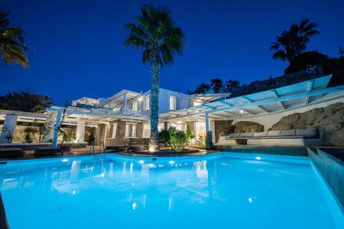 een zwembad voor een huis met een palmboom bij Sanarte Villas Mykonos in Mykonos-stad