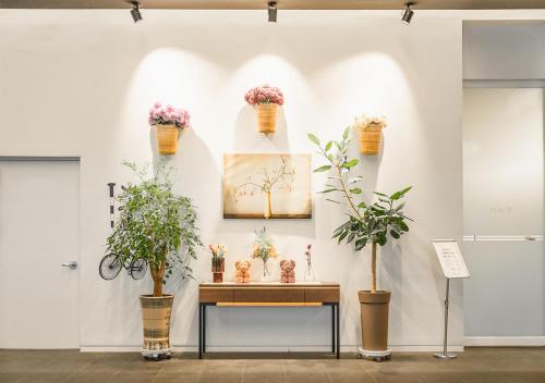 a table with potted plants on a wall at Grand City Hotel Changwon in Changwon