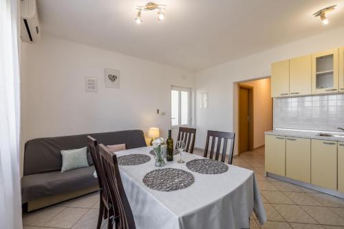 una cucina e una sala da pranzo con tavolo e divano di Cozy Apartment Tony a Dugi Rat (Punta Lunga)