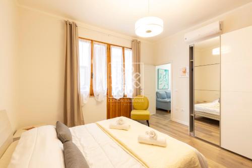 1 dormitorio con 1 cama y 1 silla amarilla en Gouenael Apartment- Castelsardo, en Castelsardo