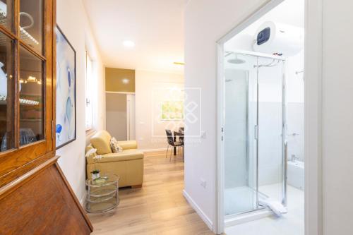 Habitación con una puerta de cristal que da a una sala de estar. en Gouenael Apartment- Castelsardo, en Castelsardo