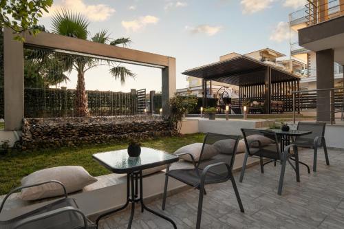 a patio with tables and chairs in a yard at StayInn Luxury Apartments in Nea Kalikratia