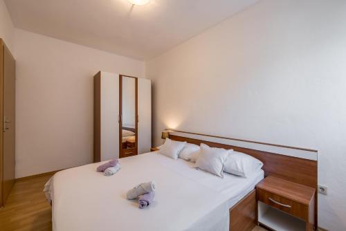 1 dormitorio con 1 cama con sábanas y almohadas blancas en Cozy Apartment Tony, en Dugi Rat
