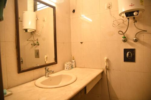 a bathroom with a sink and a mirror at Himtrek Stays Delhi in New Delhi