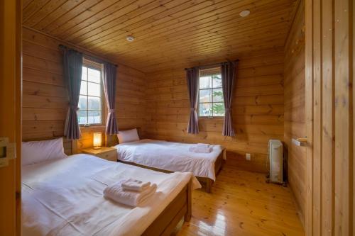 1 dormitorio con 2 camas en una cabaña de madera en Sapphire en Niseko