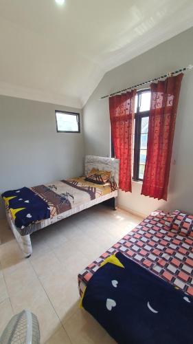 a bedroom with two beds and a window at Villa Panda N Kota Bunga Puncak in Cikundul