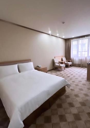 a large white bed in a hotel room at Sunjin Grand Hotel in Ulaanbaatar