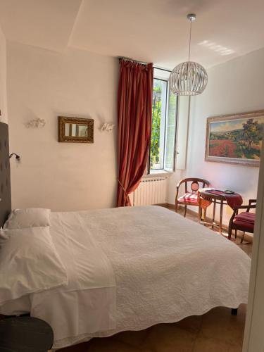 1 dormitorio con cama, ventana y mesa en La Dolce Vita en Levanto
