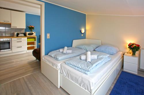 um quarto com uma cama com uma parede azul em Kuhnle-Tours Niderviller Apartments em Niderviller