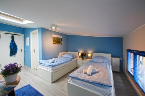 Duas camas num quarto com paredes azuis em Kuhnle-Tours Niderviller Apartments em Niderviller