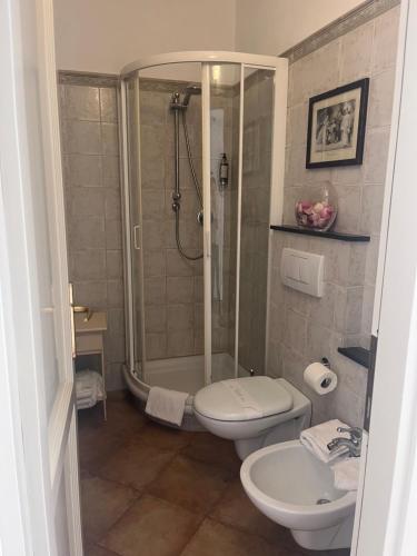 uma casa de banho com um chuveiro, um WC e um lavatório. em La Dolce Vita em Levanto