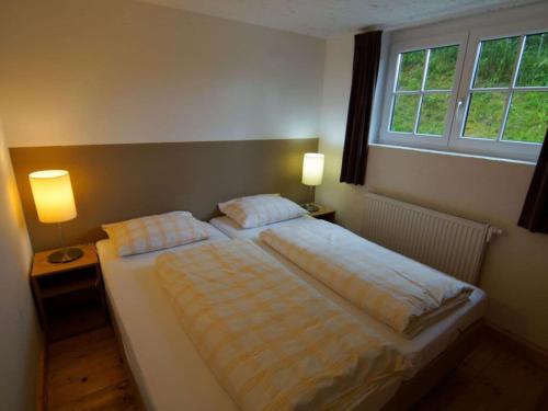 a bedroom with a bed with two pillows and a window at Chalet Grand Wastl in Wörgl