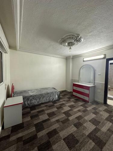 um quarto com uma cama, uma cómoda e um espelho em شقة مفروشة للايجار em Irbid