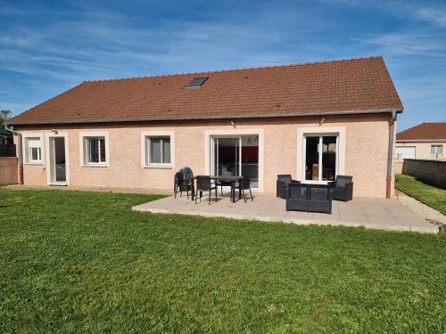 une maison avec un patio avec une table et des chaises dans l'établissement Agréable Maison proche Lac du Der, à Valcourt