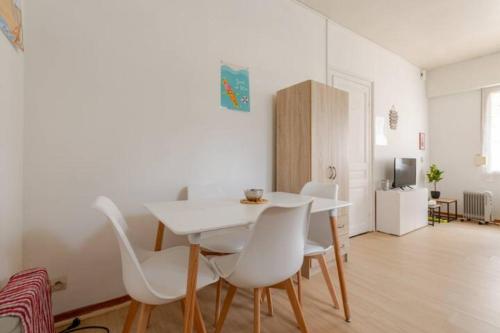 una sala da pranzo con un tavolo bianco e sedie bianche di ++++ CENTRAL STUDIO RENOVE 200 m plage et 300 m de la rue piétonne ++++ a Berck-sur-Mer