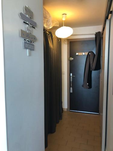 un couloir avec des panneaux de signalisation et une porte dans l'établissement Les pieds dans l'eau. Studio sur la plage, à Mauguio