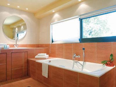 een grote badkamer met een bad en een raam bij Holiday Village - Swimming pool apartments in Kamena Vourla