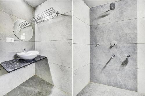 a white bathroom with a sink and a mirror at Hotel Hangout in Pune