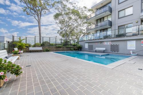 an apartment patio with a swimming pool and a building at The Poplars, 2,36 Magnus Street - Comfortable Unit With Air Conditioning and Wi-Fi in Nelson Bay