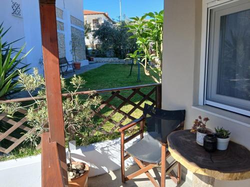 a balcony with a table and a chair and a window at The Garden Studio in Kriopigi