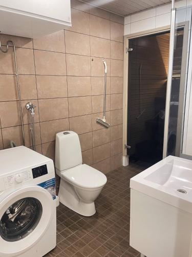 a bathroom with a toilet and a washing machine at Männikkö in Kalajoki