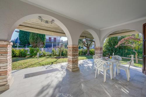 eine Terrasse mit einem Tisch und Stühlen darauf in der Unterkunft Villa Fiorita Apartments - Happy Rentals in Sirmione
