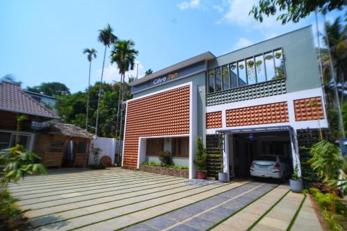 a building with a parking lot in front of it at Clive Ten Resorts Athirappilly in Kizhake Chālakudi