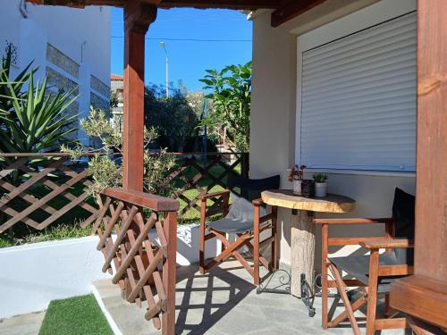 a porch with chairs and a table and a window at The Garden Studio in Kriopigi