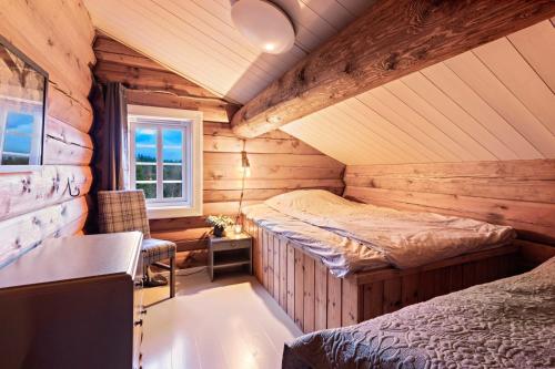 a bedroom with two beds in a log cabin at Luxurious and modern log cabin close to nature in Lislevatn