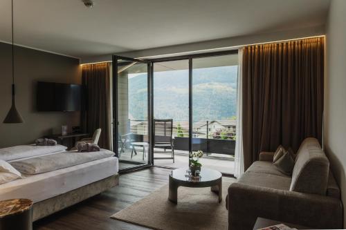 - une chambre avec un lit et un salon dans l'établissement Klein Fein Hotel Anderlahn, à Parcines