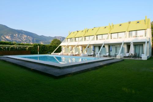 a building with a swimming pool in front of it at Holiday Village - Swimming pool apartments in Kamena Vourla