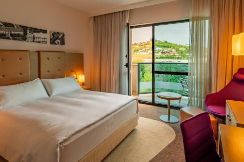 um quarto de hotel com uma cama e uma varanda em DoubleTree by Hilton Oradea em Oradea