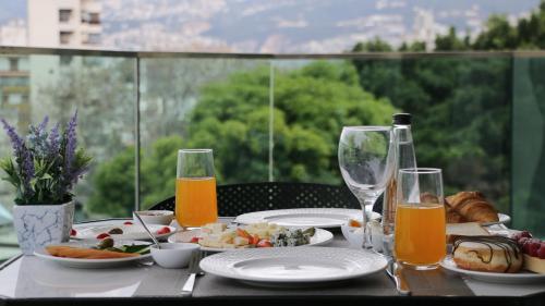 a table with plates of food and glasses of orange juice at Tilia Hotel Beirut in Beirut