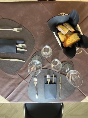 uma mesa com copos de vinho e uma cesta de pão em Atomos em Alvignano