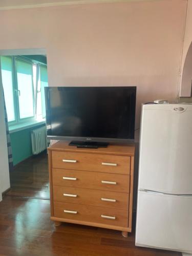 a television on a wooden dresser next to a refrigerator at apartment in Krakow