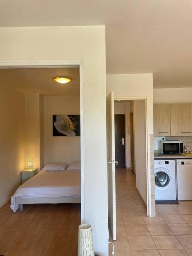 Il comprend une chambre avec un lit et une cuisine équipée d'un four micro-ondes. dans l'établissement Superbe 2P proche plages - Piscine, à Juan-les-Pins
