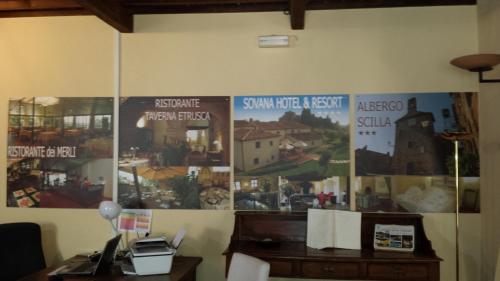 a room with posters on the wall with a desk at Hotel Scilla in Sovana