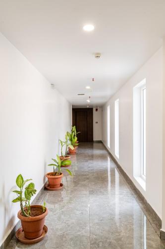 a hallway with potted plants in an office building at Pincode Hotels by Yatri Nivas in Secunderabad
