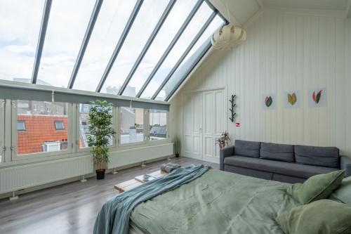 Pokój z łóżkiem, kanapą i oknami w obiekcie Penthouse Amsterdam Dam Square w Amsterdamie