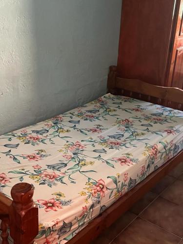 ein Bett mit einer Blumendecke darauf in der Unterkunft Maison spiritaine in Saint Esprit