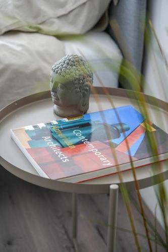 a bust of a head on a glass table at Penthouse Amsterdam Dam Square in Amsterdam